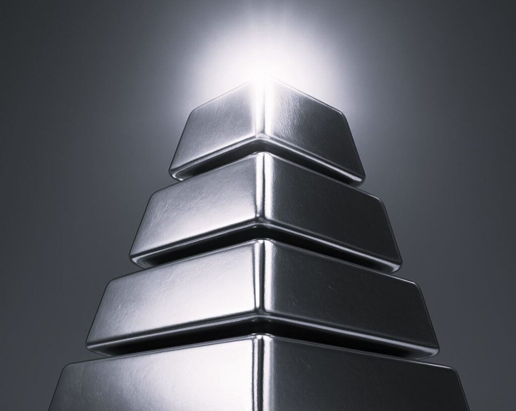 Sølvbarer stablet i pyramide med lysende top