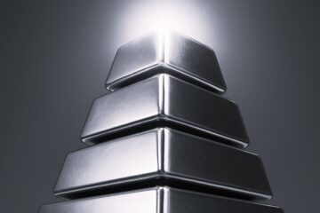 Sølvbarer stablet i pyramide med lysende top